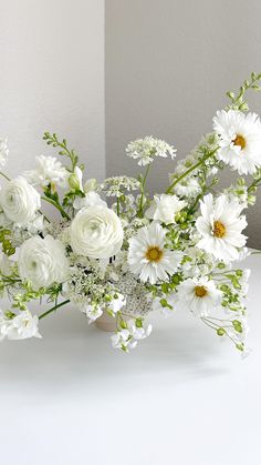 a vase filled with white flowers on top of a table