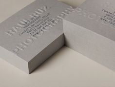 two gray business cards sitting on top of each other