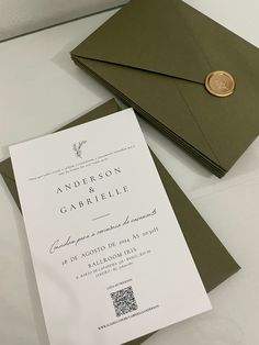 an envelope with a wax stamp on it next to a wedding card that is open