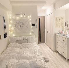 a bedroom with white furniture and lights on the wall