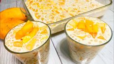 two glasses filled with fruit sitting on top of a table