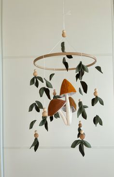 a mobile with leaves and mushrooms hanging from it