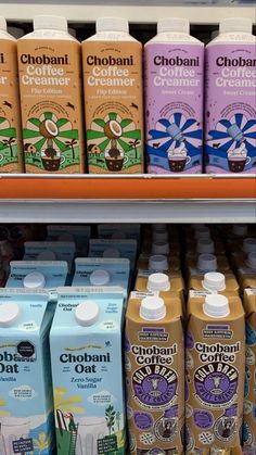 many different types of drinks on display in a grocery store, including chocolate milk and creamer