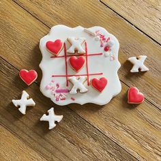 decorated cookies arranged in the shape of crosses and hearts on a wooden table with scattered confetti