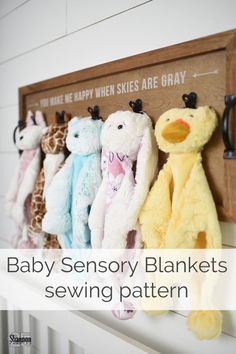 several stuffed animals are hanging on the wall in front of a sign that says baby sensory blankets sewing pattern