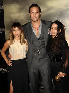 three people standing next to each other in front of a movie poster at an event