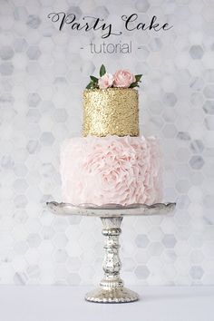 a pink and gold cake with flowers on top