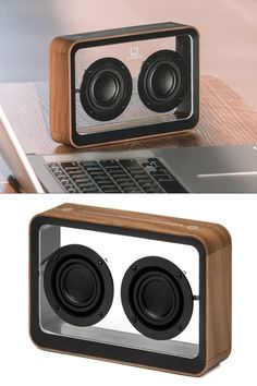 two speakers sitting on top of a wooden box next to an open laptop computer screen