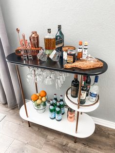 a bar cart with bottles and glasses on it