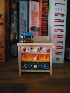 a wooden table topped with books next to a pile of books