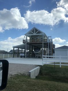 a large house sitting on top of a lush green field next to a white fence