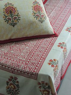 two beds covered with red and white sheets