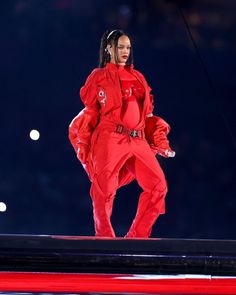 a woman in red outfit standing on stage