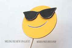 a yellow smiley face with sunglasses on top of it's head and text saying smiling face with glasses wooden photo booth prop