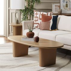 a living room filled with furniture and a plant on top of a wooden coffee table