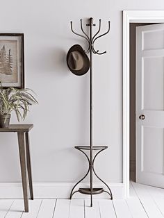 a coat rack with hats on it next to a table and chair in a room