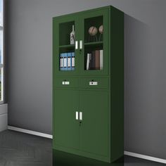 a tall green cabinet in an empty room with a view of the ocean behind it