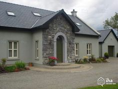 a grey house with a green door and windows