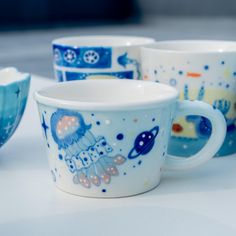 there are four cups that have designs on them