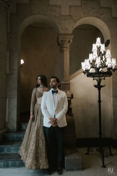 a man in a tuxedo standing next to a woman