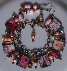 a close up of a bracelet on a plate with beads and charms hanging from it