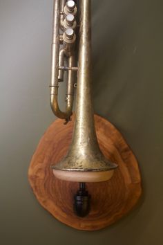 an old brass trumpet mounted to the side of a wall