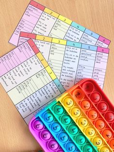 colorful plastic trays filled with numbers and shapes on top of a wooden table next to pencil