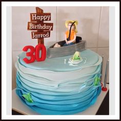 a birthday cake with a person in a boat on it and the number 30 is displayed