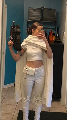 a woman is taking a selfie in the mirror while wearing white pants and top