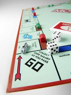 a close up of a monopoly board game with dices and other items on it