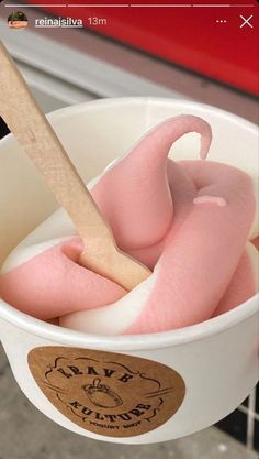 an ice cream bucket with pink stuff in it and a wooden spoon sticking out of the top