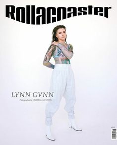 a magazine cover with a woman in white pants and tattoos on her arm, posing for the camera