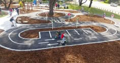 several children are playing in an outdoor play area with trees and grass on both sides