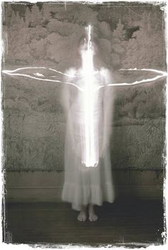 a woman standing in front of a wall with light painting on it's face