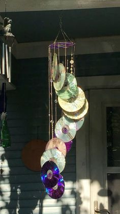 a wind chime hanging from the side of a house with lots of discs on it