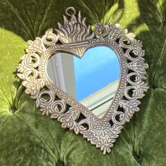 a heart shaped mirror sitting on top of a green couch