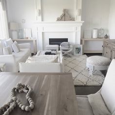 a living room filled with furniture and a fire place next to a white couches