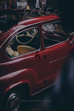 an old red car parked on the street