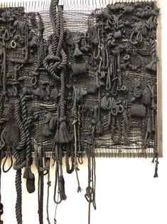 there are many pieces of art made out of rope and cords hanging on the wall