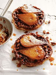 two desserts sitting on top of a piece of paper next to a bowl of nuts