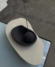 a black and white hat sitting on top of a glass table