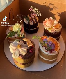 there are four cakes on the table with flowers