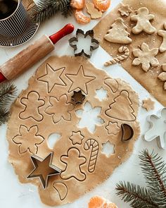 cookie cutters and cookies are arranged on a table with christmas decorations, baking utensils and other items