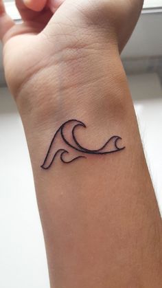 a small wave tattoo on the wrist