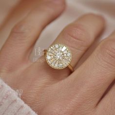 a woman's hand with a diamond ring on top of her finger, showing the center stone