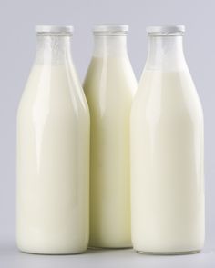 three bottles of milk sitting next to each other