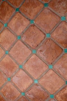 an orange cat laying on top of a brown and green tiled floor next to a red fire hydrant