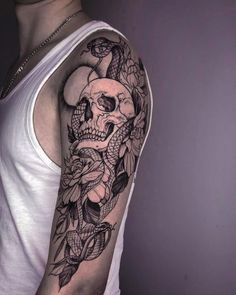 a man with a skull and flowers tattoo on his arm