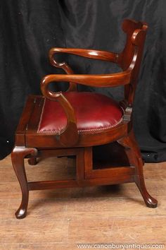 a wooden chair with red leather upholstered on the seat and armrests