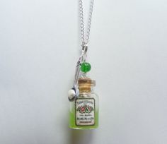 a small bottle with a green cap is hanging from a chain